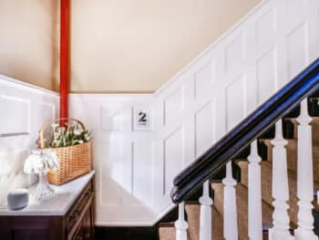 stairwell image showing black painted railing and white beadboard